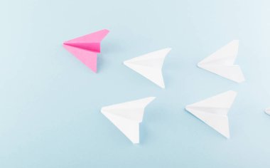 Birçok olanlar arasında bir benzersiz pembe kağıt uçak. Bireysellik ve liderlik kavramı olarak farklı kağıt uçak