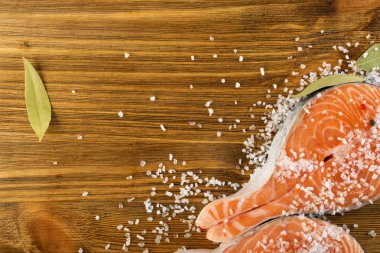 Doğal eski ahşap tahta üzerinde ham tuzlanmış somon Steak. Kalın adet taze kırmızı balık veya alabalık üstten görünüm ile boşaltmak