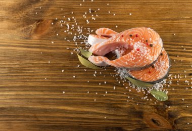 Doğal eski ahşap tahta üzerinde ham tuzlanmış somon Steak. Kalın adet taze kırmızı balık veya alabalık üstten görünüm ile boşaltmak
