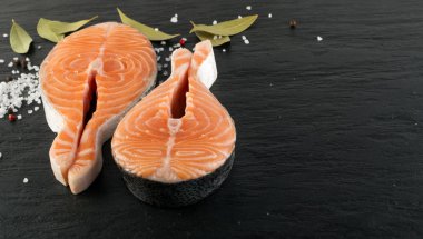 Doğal taş üzerinde ham tuzlanmış somon Steak. Taze kırmızı balık ya da alabalık siyah arka plan üzerine kalın parça