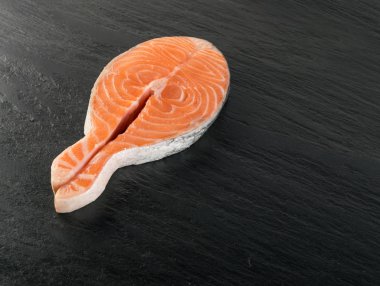 Doğal siyah arka plan üzerine çiğ somon Steak dilim. Taze kırmızı balık veya görünümünün alabalık en iyi yer ile metin için kalın parça