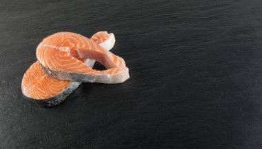 Doğal siyah arka plan üzerine çiğ somon Steak dilim. Taze kırmızı balık veya görünümünün alabalık en iyi yer ile metin için kalın parça