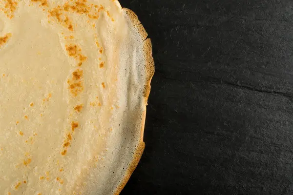 Siyah taş zemin üstten görünüm üzerinde ince krep. Taze ev yapımı krep veya metin alanı olan Lay düz gözleme