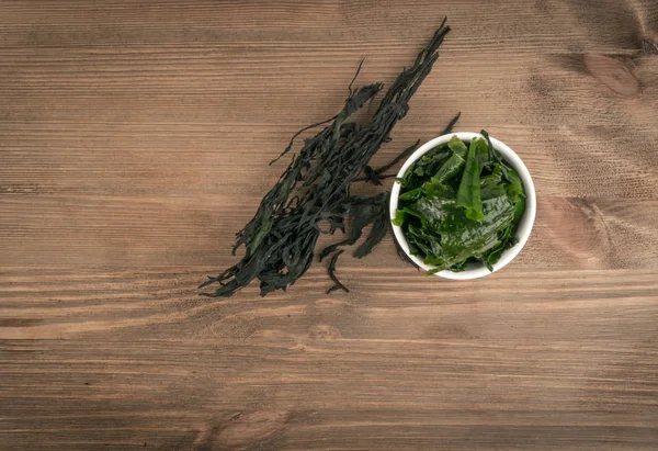 Heap of Dry Wakame Seaweed on Wooden Background. Healthy Algae Food with Place for Text