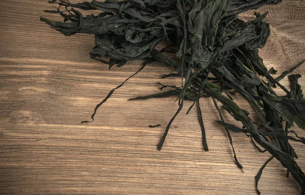 Heap of Dry Wakame Seaweed on Wooden Background. Healthy Algae Food with Place for Text