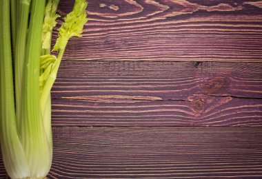 Ham yeşil kereviz ahşap arka plan üstten görünüm üzerinde takip ediyor. Eski ahşap rustik masa metin veya boşaltmak için yer ile taze organik sebze