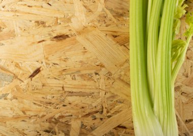 Ham yeşil kereviz ahşap arka plan üstten görünüm üzerinde takip ediyor. Eski ahşap rustik masa metin veya boşaltmak için yer ile taze organik sebze