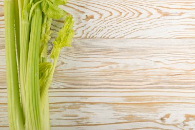 Ham yeşil kereviz ahşap arka plan üstten görünüm üzerinde takip ediyor. Eski ahşap rustik masa metin veya boşaltmak için yer ile taze organik sebze
