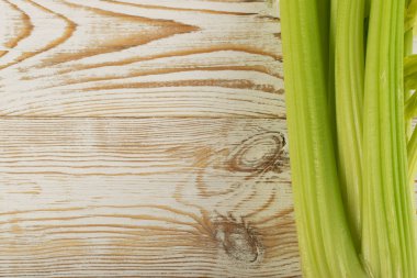 Ham yeşil kereviz ahşap arka plan üstten görünüm üzerinde takip ediyor. Eski ahşap rustik masa metin veya boşaltmak için yer ile taze organik sebze