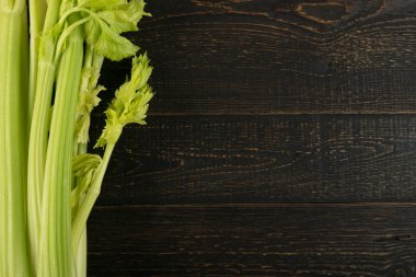 Ham yeşil kereviz ahşap arka plan üstten görünüm üzerinde takip ediyor. Eski ahşap rustik masa metin veya boşaltmak için yer ile taze organik sebze
