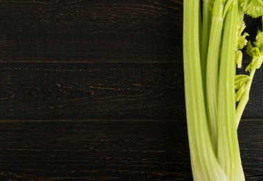 Ham yeşil kereviz ahşap arka plan üstten görünüm üzerinde takip ediyor. Eski ahşap rustik masa metin veya boşaltmak için yer ile taze organik sebze