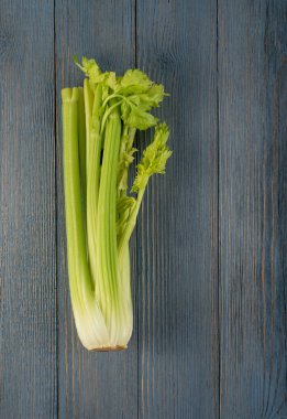 Ham yeşil kereviz ahşap arka plan üstten görünüm üzerinde takip ediyor. Eski ahşap rustik masa metin veya boşaltmak için yer ile taze organik sebze