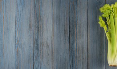 Ham yeşil kereviz ahşap arka plan üstten görünüm üzerinde takip ediyor. Eski ahşap rustik masa metin veya boşaltmak için yer ile taze organik sebze