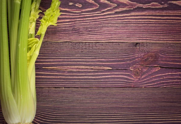 Ham yeşil kereviz ahşap arka plan üstten görünüm üzerinde takip ediyor. Eski ahşap rustik masa metin veya boşaltmak için yer ile taze organik sebze