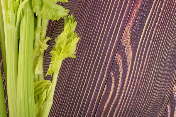 Ham yeşil kereviz ahşap arka plan üstten görünüm üzerinde takip ediyor. Eski ahşap rustik masa metin veya boşaltmak için yer ile taze organik sebze
