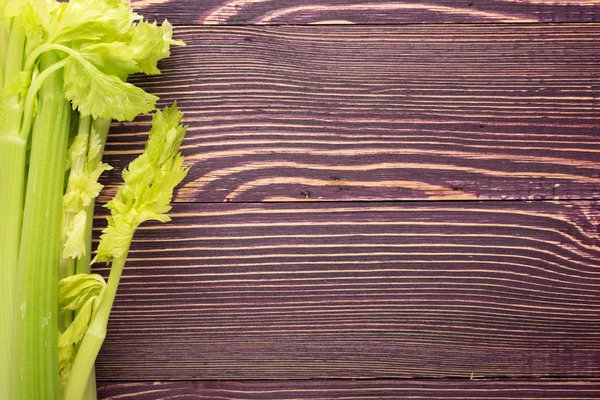 Ham yeşil kereviz ahşap arka plan üstten görünüm üzerinde takip ediyor. Eski ahşap rustik masa metin veya boşaltmak için yer ile taze organik sebze