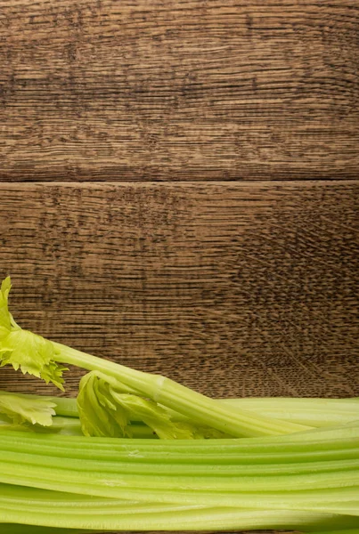 Ham yeşil kereviz ahşap arka plan üstten görünüm üzerinde takip ediyor. Eski ahşap rustik masa metin veya boşaltmak için yer ile taze organik sebze