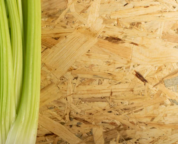 Ham yeşil kereviz ahşap arka plan üstten görünüm üzerinde takip ediyor. Eski ahşap rustik masa metin veya boşaltmak için yer ile taze organik sebze