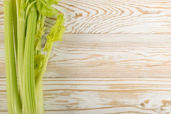Ham yeşil kereviz ahşap arka plan üstten görünüm üzerinde takip ediyor. Eski ahşap rustik masa metin veya boşaltmak için yer ile taze organik sebze