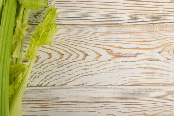Ham yeşil kereviz ahşap arka plan üstten görünüm üzerinde takip ediyor. Eski ahşap rustik masa metin veya boşaltmak için yer ile taze organik sebze