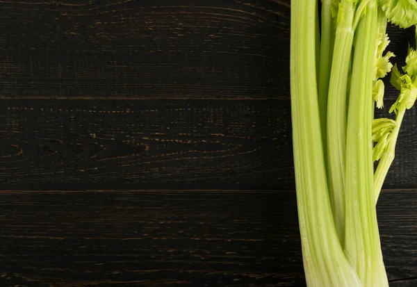 Ham yeşil kereviz ahşap arka plan üstten görünüm üzerinde takip ediyor. Eski ahşap rustik masa metin veya boşaltmak için yer ile taze organik sebze