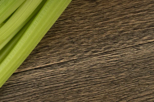 Ham yeşil kereviz ahşap arka plan üstten görünüm üzerinde takip ediyor. Eski ahşap rustik masa metin veya boşaltmak için yer ile taze organik sebze