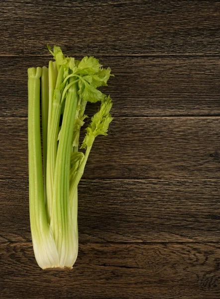 Ham yeşil kereviz ahşap arka plan üstten görünüm üzerinde takip ediyor. Eski ahşap rustik masa metin veya boşaltmak için yer ile taze organik sebze