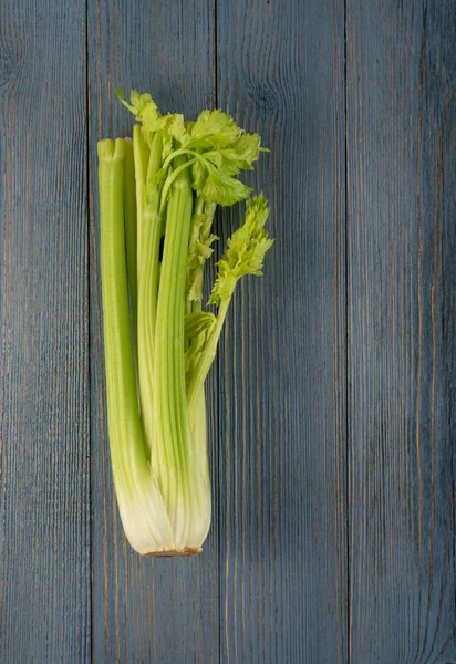 Ham yeşil kereviz ahşap arka plan üstten görünüm üzerinde takip ediyor. Eski ahşap rustik masa metin veya boşaltmak için yer ile taze organik sebze