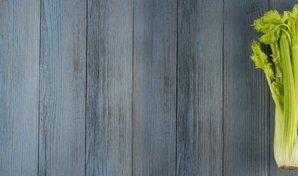 Ham yeşil kereviz ahşap arka plan üstten görünüm üzerinde takip ediyor. Eski ahşap rustik masa metin veya boşaltmak için yer ile taze organik sebze
