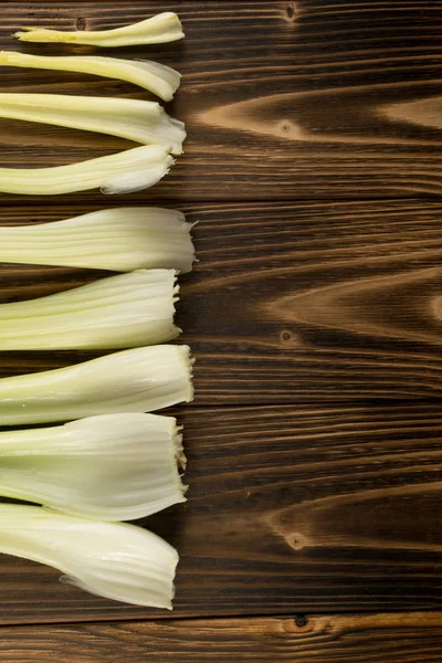 Ham yeşil kereviz ahşap arka plan üstten görünüm üzerinde takip ediyor. Eski ahşap rustik masa metin veya boşaltmak için yer ile taze organik sebze