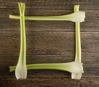 Ham yeşil kereviz ahşap arka plan üstten görünüm üzerinde takip ediyor. Taze organik kare sebze çerçeve boşaltmak eski ahşap rustik tablo