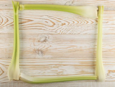 Ham yeşil kereviz ahşap arka plan üstten görünüm üzerinde takip ediyor. Taze organik kare sebze çerçeve boşaltmak eski ahşap rustik tablo