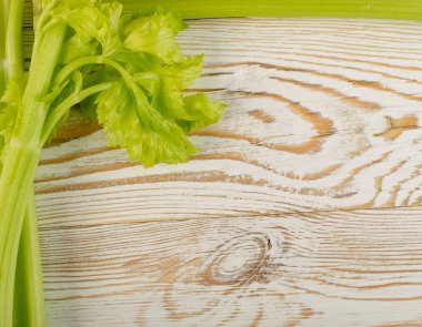 Ham yeşil kereviz ahşap arka plan üstten görünüm üzerinde takip ediyor. Eski ahşap rustik masa metin veya boşaltmak için yer ile taze organik sebze