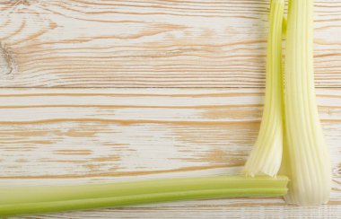 Ham yeşil kereviz ahşap arka plan üstten görünüm üzerinde takip ediyor. Eski ahşap rustik masa metin veya boşaltmak için yer ile taze organik sebze