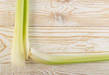 Ham yeşil kereviz ahşap arka plan üstten görünüm üzerinde takip ediyor. Eski ahşap rustik masa metin veya boşaltmak için yer ile taze organik sebze