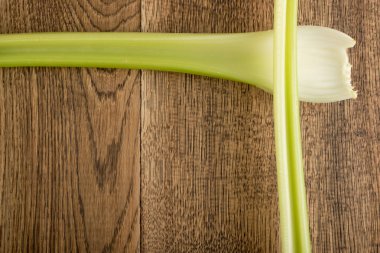 Ham yeşil kereviz ahşap arka plan üstten görünüm üzerinde takip ediyor. Eski ahşap rustik masa metin veya boşaltmak için yer ile taze organik sebze