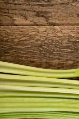 Ham yeşil kereviz ahşap arka plan üstten görünüm üzerinde takip ediyor. Eski ahşap rustik masa metin veya boşaltmak için yer ile taze organik sebze