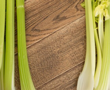 Ham yeşil kereviz ahşap arka plan üstten görünüm üzerinde takip ediyor. Eski ahşap rustik masa metin veya boşaltmak için yer ile taze organik sebze