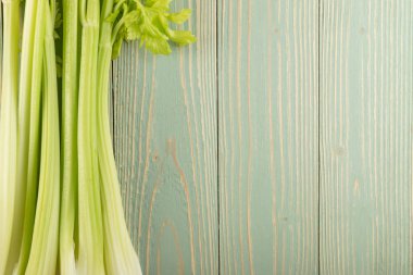 Ham yeşil kereviz ahşap arka plan üstten görünüm üzerinde takip ediyor. Eski ahşap rustik masa metin veya boşaltmak için yer ile taze organik sebze