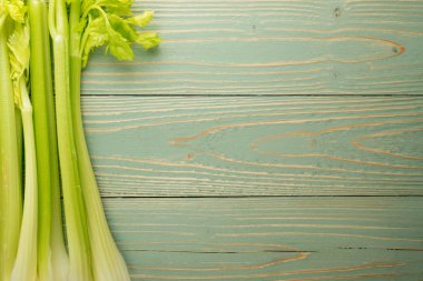 Ham yeşil kereviz ahşap arka plan üstten görünüm üzerinde takip ediyor. Eski ahşap rustik masa metin veya boşaltmak için yer ile taze organik sebze