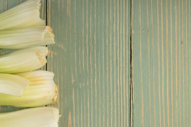 Ham yeşil kereviz ahşap arka plan üstten görünüm üzerinde takip ediyor. Eski ahşap rustik masa metin veya boşaltmak için yer ile taze organik sebze