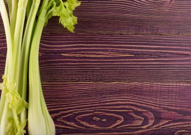 Ham yeşil kereviz ahşap arka plan üstten görünüm üzerinde takip ediyor. Eski ahşap rustik masa metin veya boşaltmak için yer ile taze organik sebze