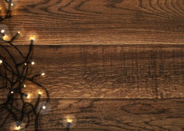 Ahşap arka plan boşaltmak ile üstten görünüm Noel ışığı. Yeni yıl çerçeve veya Xmas Mockup Vintage ahşap doku Garland ışıkları