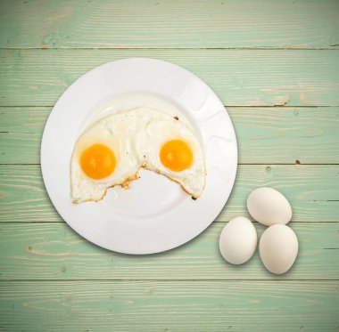 İki kızarmış yumurta beyaz ahşap Backgroynd üst görünüm üzerinde plaka ve yat