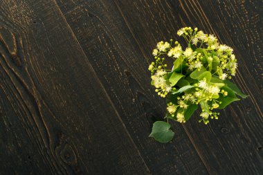 Ihlamur çiçek ahşap arka plan üzerinde. Güzel yaz buket ahşap masa doku üzerinde. Ihlamur çiçeği ile metin için yer
