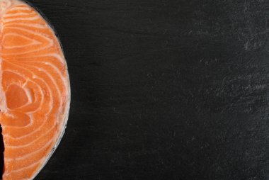 Doğal siyah arka plan üzerine çiğ somon Steak dilim. Taze kırmızı balık veya görünümünün alabalık en iyi yer ile metin için kalın parça