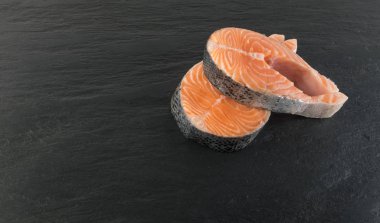 Doğal siyah arka plan üzerine çiğ somon Steak dilim. Taze kırmızı balık veya görünümünün alabalık en iyi yer ile metin için kalın parça