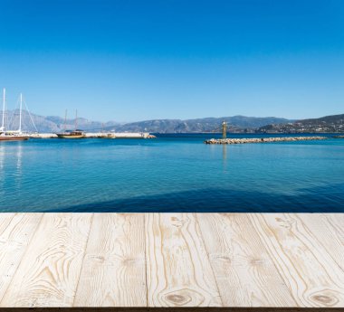Güzel yaz günü manzaralı ahşap masa dışında. Rustik ahşap Resepsiyon deniz görünümü arka plan üzerine açık. Şablon ürün reklam için tezgah ile sahte