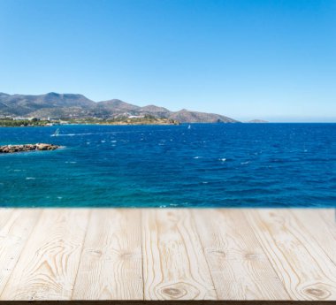 Güzel yaz günü manzaralı ahşap masa dışında. Rustik ahşap Resepsiyon deniz görünümü arka plan üzerine açık. Şablon ürün reklam için tezgah ile sahte