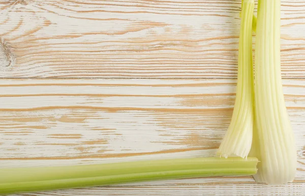 Ham yeşil kereviz ahşap arka plan üstten görünüm üzerinde takip ediyor. Eski ahşap rustik masa metin veya boşaltmak için yer ile taze organik sebze